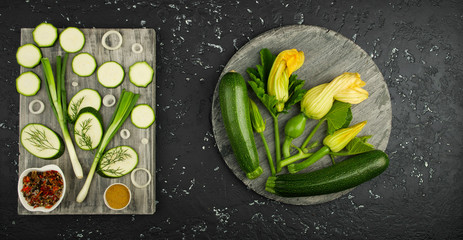 Fresh green zucchini on a dark table. The view from the top. Copy space.