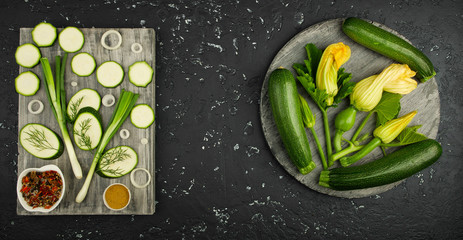 Fresh green zucchini on a dark table. The view from the top. Copy space.