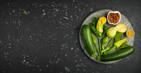 Fresh green zucchini on a dark table. The view from the top. Copy space.