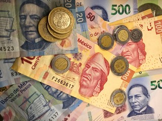 Mexican peso bills spread randomly over a flat surface