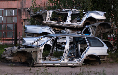crumpled bodies of disassembled old cars stand on the ground