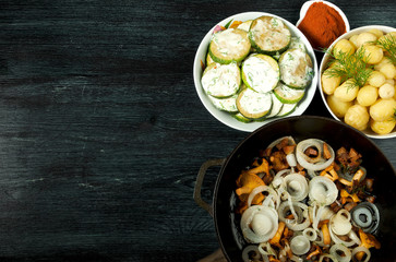 Vegetables on the background. Fried zucchini sauce in a plate. Young boiled potatoes with dill in a bowl. Fried chanterelle mushrooms with golden onions in a frying pan. copy space