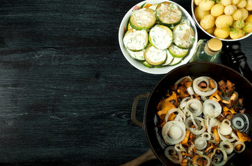 Vegetables on the background. Fried zucchini sauce in a plate. Young boiled potatoes with dill in a bowl. Fried chanterelle mushrooms with golden onions in a frying pan. copy space