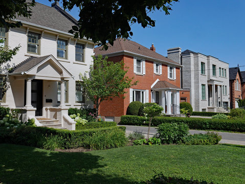 Street Of Large Suburban Detached Houses With Front Yards On A Sunny Summer Day