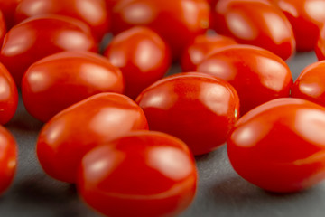Fresh cherry tomatoes on grey stone background. Shallow focus.