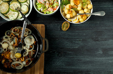 Vegetables on the background. Fried zucchini sauce in a plate. Young boiled potatoes with dill in a bowl. Fried chanterelle mushrooms with golden onions in a frying pan. copy space