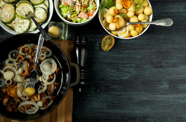 Vegetables on the background. Fried zucchini sauce in a plate. Young boiled potatoes with dill in a bowl. Fried chanterelle mushrooms with golden onions in a frying pan. copy space