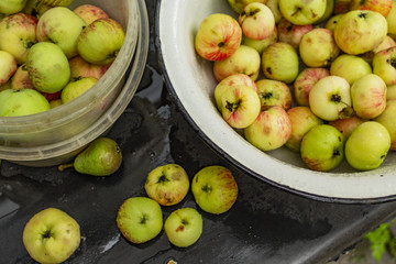 Apples and the pear in the box and on the dark background. Drops of water. Green fruits.