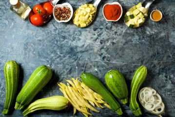 Vegetables on the background. Fresh vegetables (cucumbers, tomatoes, onions, garlic, dill, green beans) on a gray background. Top view. Copy space
