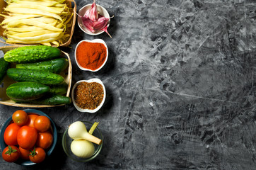 Vegetables on the background. Fresh vegetables (cucumbers, tomatoes, onions, garlic, dill, green beans) on a gray background. Top view. Copy space