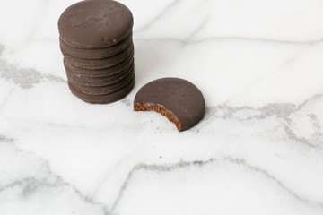Stack of thin mints cookies on white marble background, chocolate mint thin round cookies