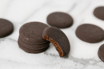 Stack of thin mints cookies on white marble background, chocolate mint thin round cookies