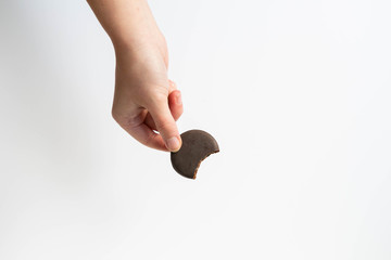 Girl holding thin mints cookies with bite taken out, chocolate mint thin round cookies