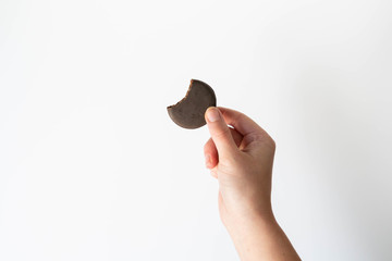 Girl holding thin mints cookies with bite taken out, chocolate mint thin round cookies