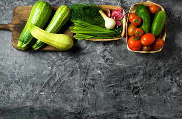 Vegetables on the background. Fresh vegetables (cucumbers, tomatoes, onions, garlic, dill, green beans) on a gray background. Top view. Copy space