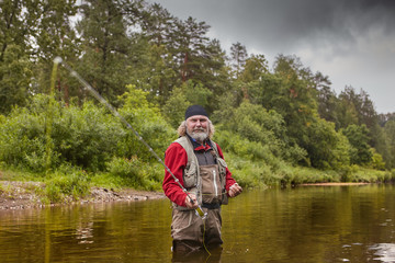 Fototapeta na wymiar Mature man during fly fishing in river.