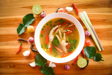 Chicken Feet Spicy Soup / Chicken Foot with hot and sour soup bowl with fresh vegetables Tom Yum thai herbs and spices ingredients with chilli lemon on wooden background Thai Food Asian