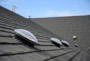 Dome shaped solar tube skylight on asphalt shingle roof  - Powered by Adobe