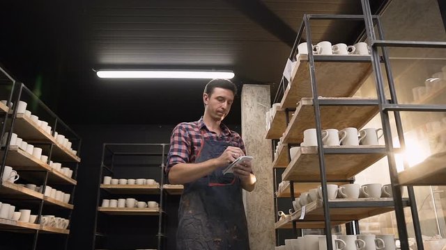 Bottom view of middle age man noting something in the notebook.