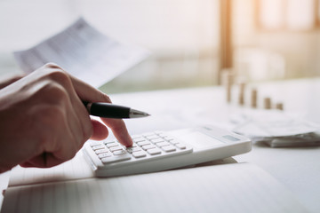 Man use calculators and documents that calculate expenses in the home office.