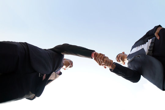 Businessmen handshaking after successful business meeting, negotiation. Perspective shoot from below. Muslim Business Men Shakes hand. Team Teamwork Togetherness Collaboration Concept.