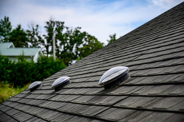 Dome shaped solar tube skylight on asphalt shingle roof  - Powered by Adobe