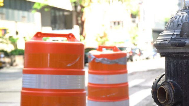 New York Avenue background video - shot mid-day with roadwork cones and fire hydrant in focus while people, cars and yellow cabs pass behind