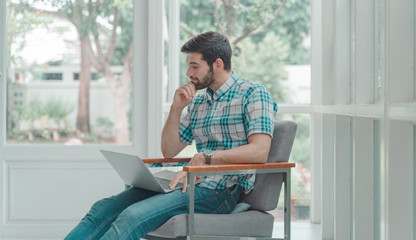   Young modern businessman relaxing with notebook  while sitting in the office. The successful business analysis, creative design to analyze the management of the investment. Real estate market trends