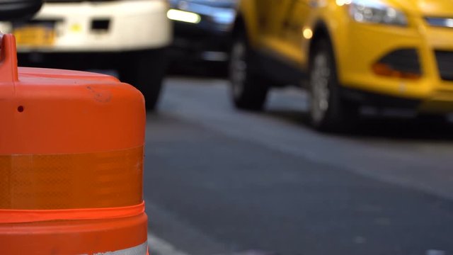 New York Street at rush hour showing taxi, bus and cars stopped at a red light, traffic moving slowly, smoking manhole cover in the background