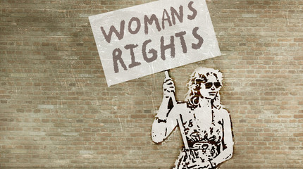 Graffiti with a woman standing with a sign on `Womens Rigths` painted on one on a wall