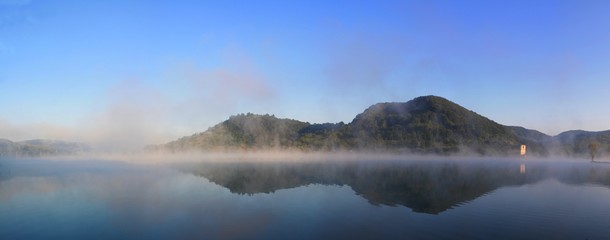 panoramic landscape with fog on the lake in the morning