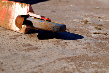 Old red rusty abandoned scooter lying on the concrete floor.