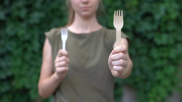 Lady showing wooden fork to cam preferring natural materials to plastic, ecology