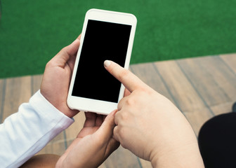Close up of two girls hand showing a blank smart phone screen