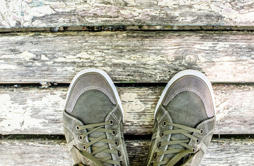 Green sneakers on a brown wooden background 
