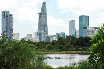 A different view of Ho Chi Minh City, Vietnam's modern skyline with green jungle landscape next to skyscrapers and high rise buildings