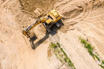 heavy yellow excavator moving the sand at construction site