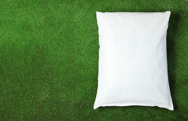 Bag with soil on green grass, top view with space for text. Gardening time