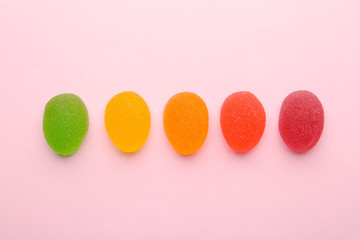 Tasty bright jelly candies on color background, flat lay