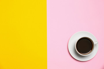 Cup of coffee on color background, top view. Space for text