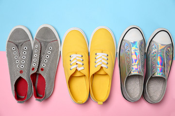 Modern trendy sneakers on color background, top view