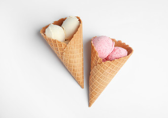 Delicious ice creams in wafer cones on white background, top view