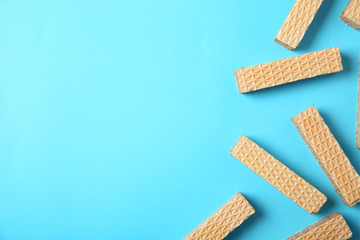 Flat lay composition with delicious crispy wafers on blue background. Space for text