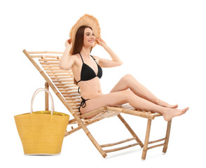 Young woman with bag on sun lounger against white background. Beach accessories