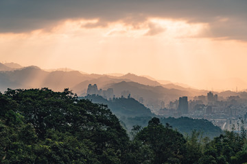Layers of Taipei cityscape and mountains with sunlight when the sun going down that view from Xiangshan Elephant Mountain in the evening in Taipei, Taiwan.
