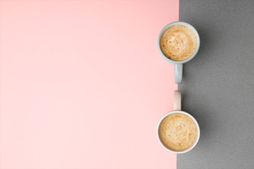 Cups of coffee on color background, top view. Space for text