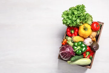 Fototapeten Crate with different fresh vegetables on light background, top view. Space for text © New Africa