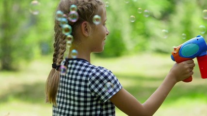 Girl playing with soap bubbles outdoor. Slow motion.
