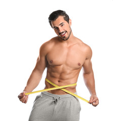 Young man with slim body using measuring tape on white background