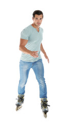 Handsome young man with inline roller skates on white background